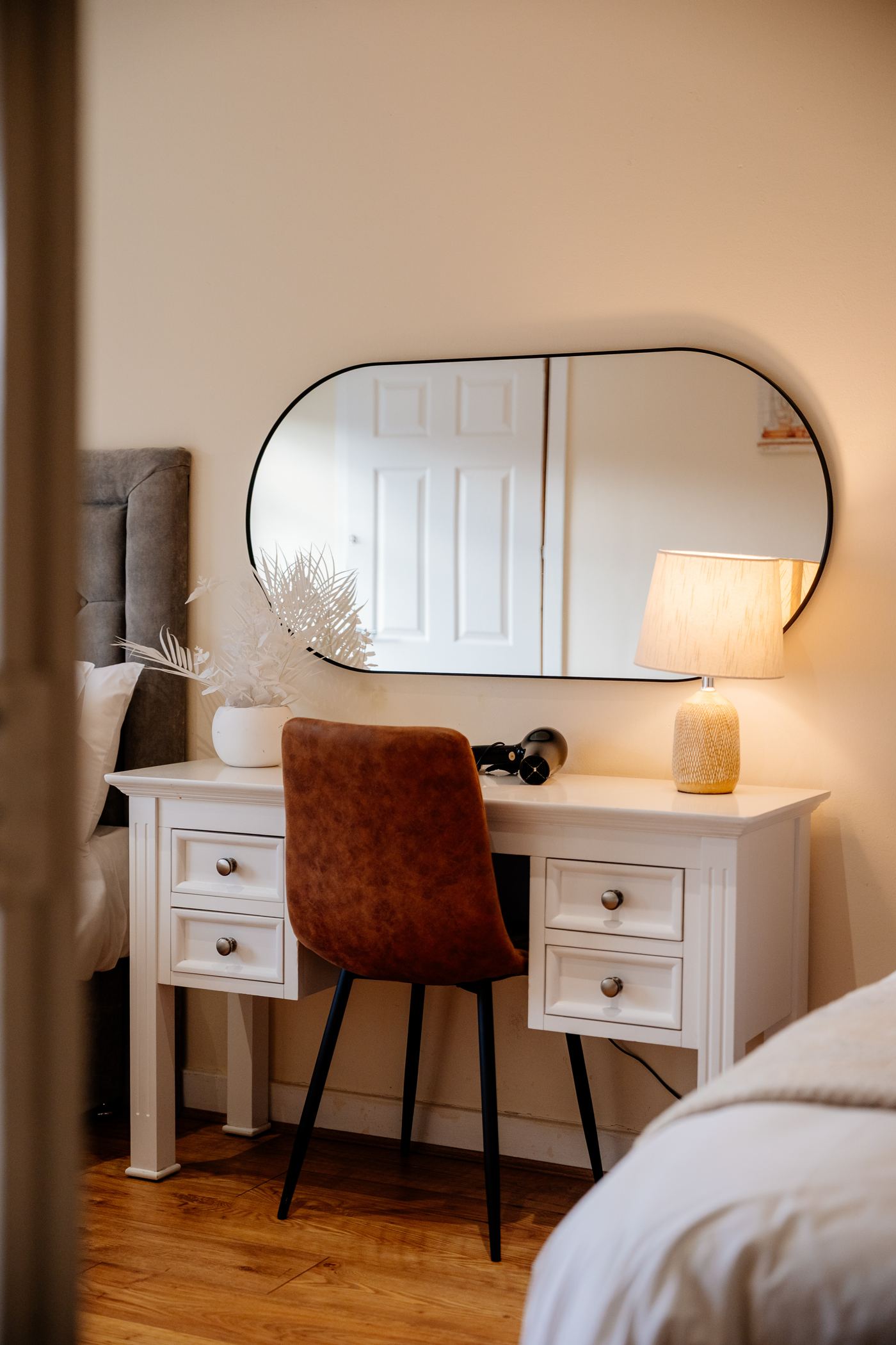 A desk with a mirror and lamp in a bedroom of an Edinburgh short let