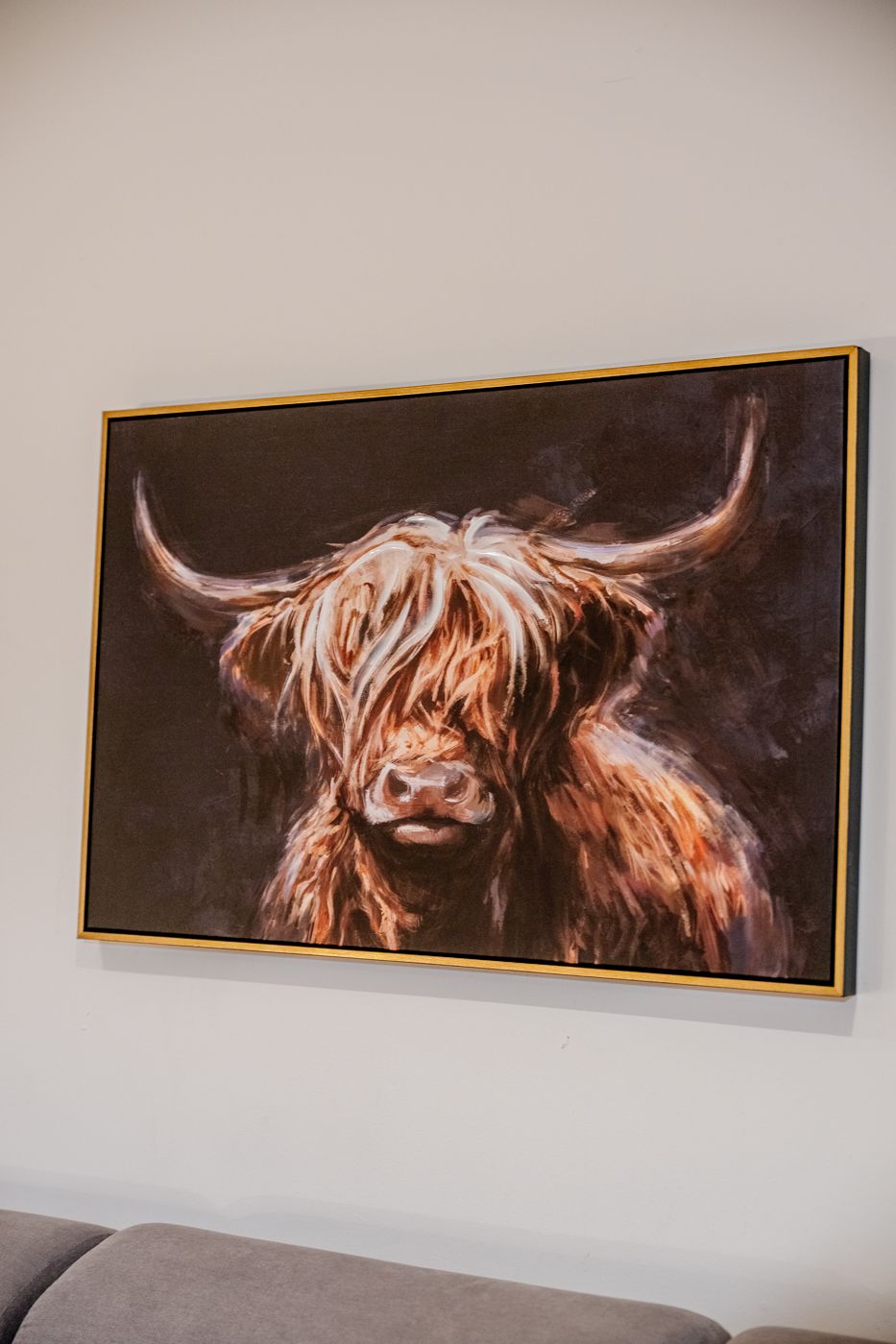 Framed Highland cow painting above the sofa, near Easter Road