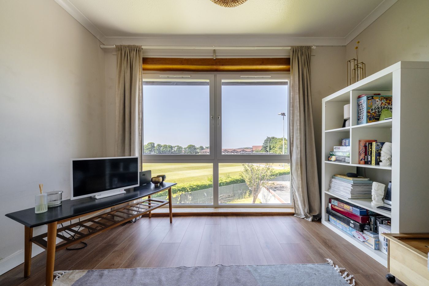 Living room window looking out over green playing fields in a home we look after in Morningside