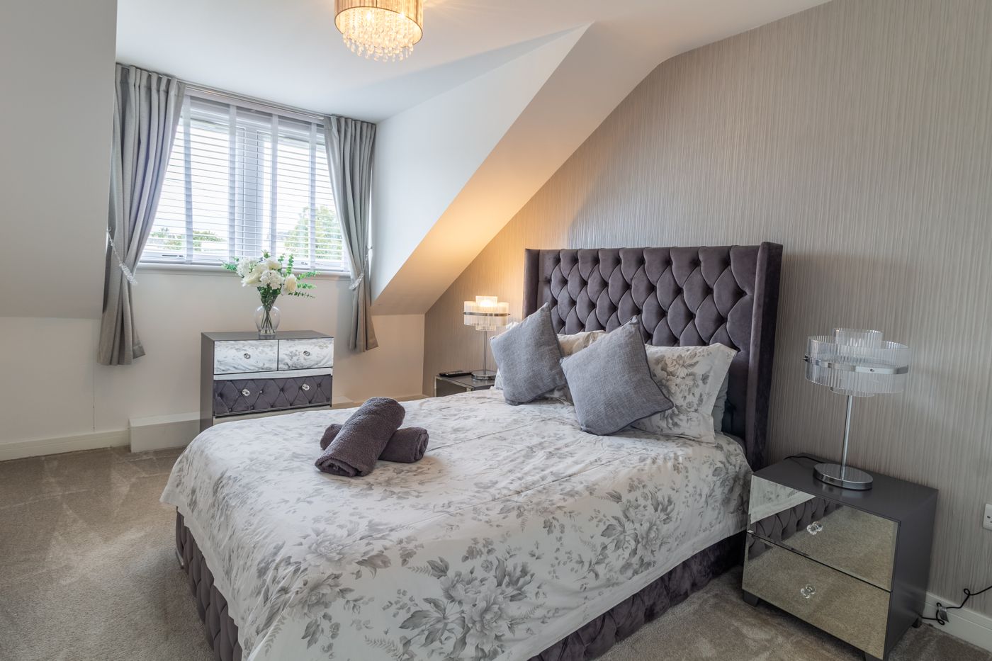 Main bedroom with a tall buttoned headboard and mirrored bedside tables, in Prestonfield
